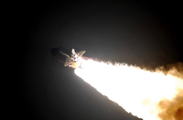 In this stunning picture following the launch, the glare from Endeavour's three main rocket engines and flanking solid fuel booster rockets illuminates the orbiter's tail section and the large, orange external fuel tank. (http://apod.nasa.gov)